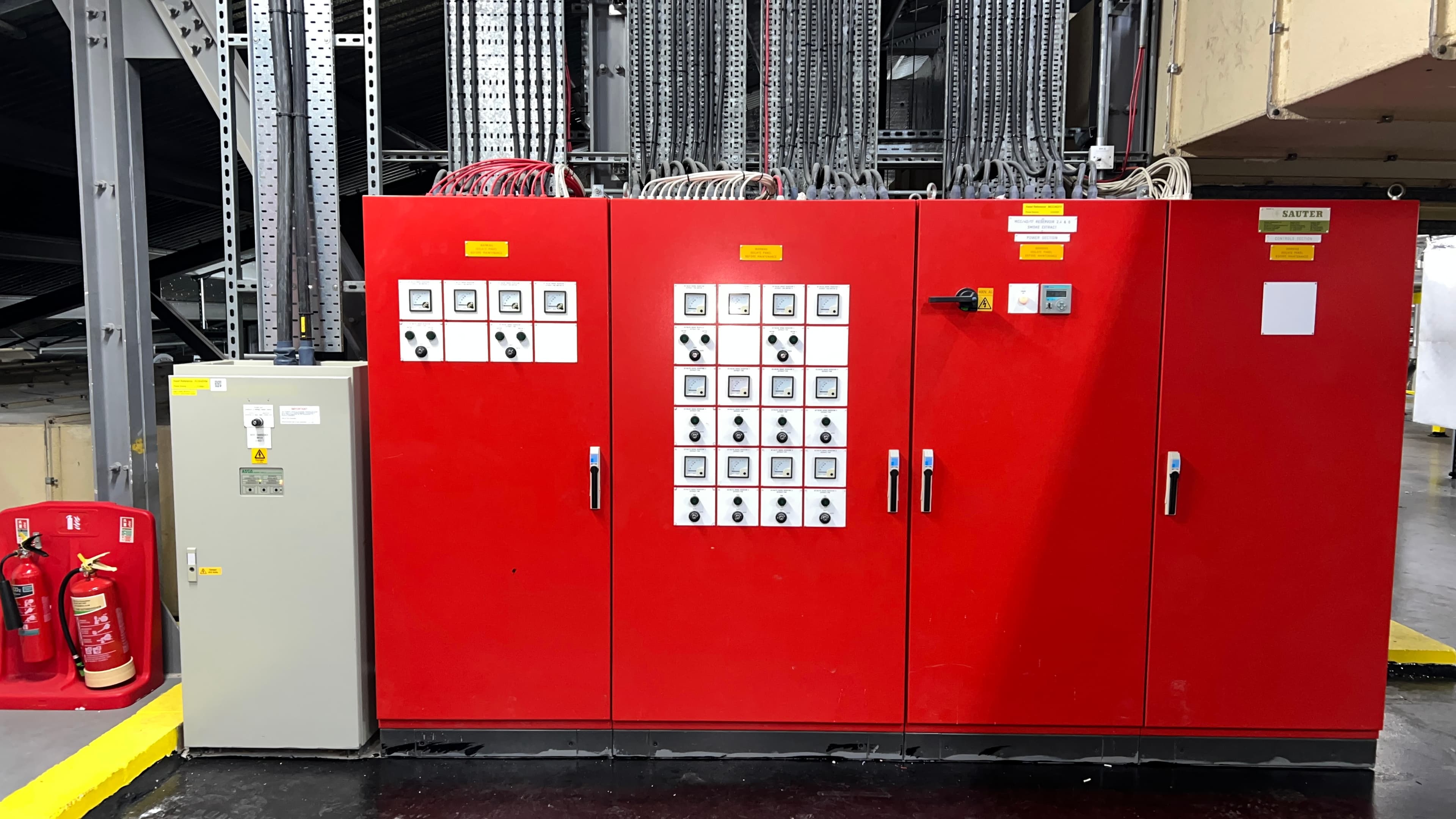 Four red electrical control panels with inverter displays