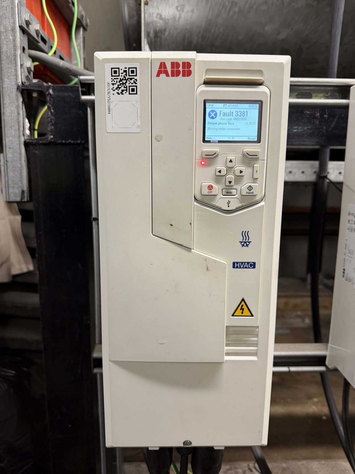 ABB ACH580 HVAC variable speed drive mounted in a plant room with its keypad showing Fault 3381 output phase loss and the red fault LED lit