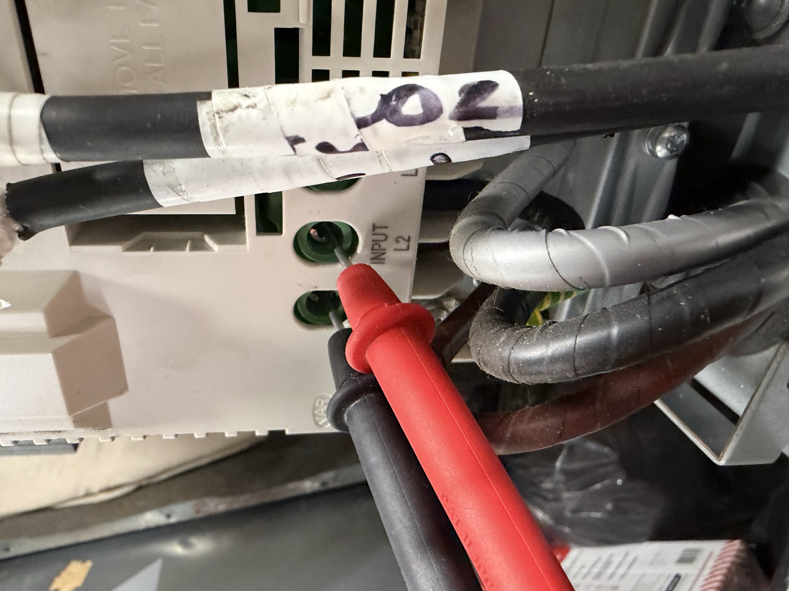 Multimeter probes on ABB ACH580 input terminals during supply check