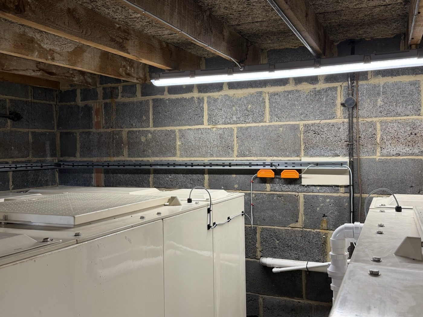 GRP cold water storage tanks in a rooftop tank room fitted with high and low level float switches