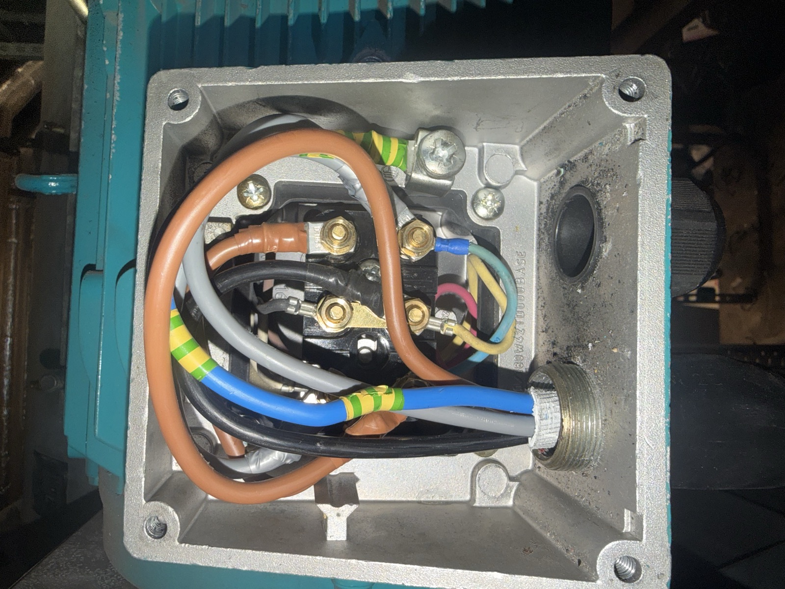 Open three phase motor terminal box showing six studs and brass linking strips