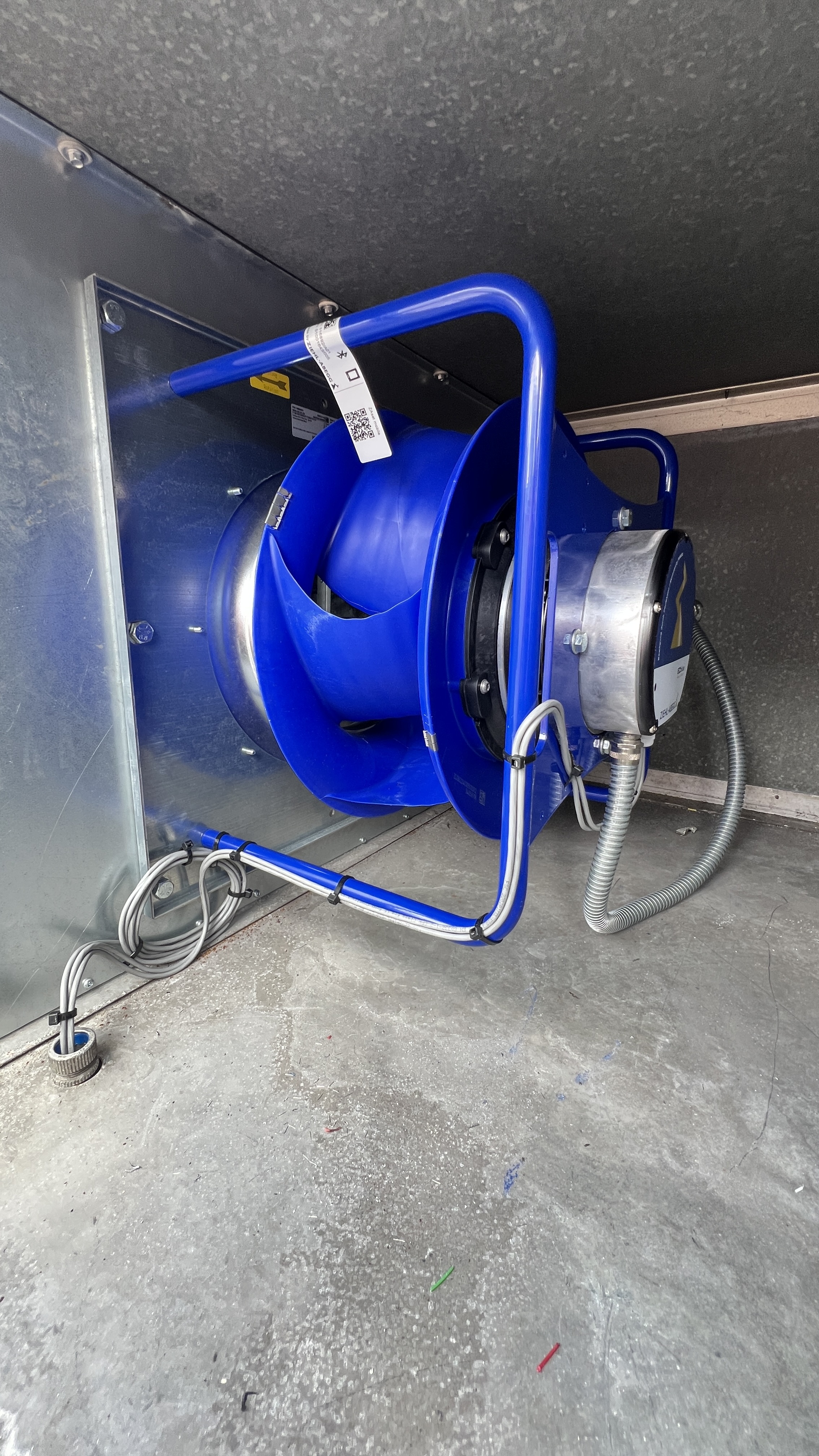 Blue industrial cable reel mounted in wall alcove