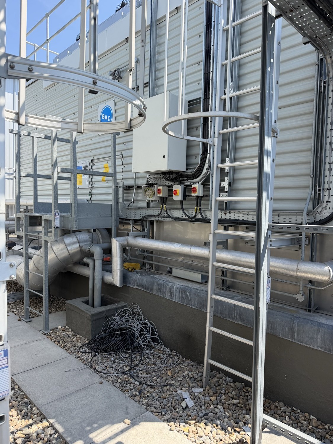 Data centre BMS alarm management — rooftop cooling tower with local isolators and control enclosure at a live London data centre